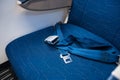 An unfastened seat belt on an empty seat in an airplane. Safety in flight