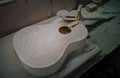 Unfinished acoustic guitar body wood with no components at workshop . Royalty Free Stock Photo