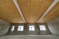 Unfinished apartment or house big loft room under reconstruction. Plywood ceiling, plastered walls, window openings, cement floor Royalty Free Stock Photo