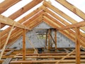 Unfinished attic house roofing construction trusses, wooden beams, eaves, timber. House roof wooden frame construction