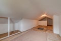 Unfinished attic wood floor white walls A-frame ceiling
