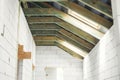 Unfinished attic wooden roof framing with vapor barrier, dormer and windows. View on timber rafters and beams on aerated concrete