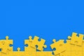 Unfinished blank jigsaw puzzle pieces on blue background. Copy space. Flat lay