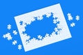 Unfinished blank jigsaw puzzle pieces on blue background. Flat lay