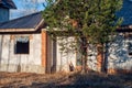 Unfinished brick country house. Abandoned cottage village overgrown with trees Royalty Free Stock Photo