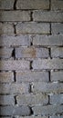 Unfinished bricks house wall background texture at the construction site. Grey ruined industrial brick wall with copy space.