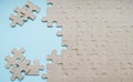 Unfinished cardboard puzzle without pattern. A blue background on the left and a few scattered pieces of the puzzle. Copy space Royalty Free Stock Photo