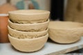 Unfinished clay plates on shelf of pottery workshop - close up