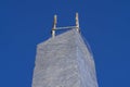 Unfinished concrete column under tower construction with protruded steel reinforcement bar and with clear plastic wrap around for