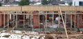 Unfinished construction site of a red brick rural house in the winter frozen village Royalty Free Stock Photo