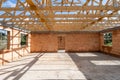 Unfinished house with red brick walls under wooden roof beams Royalty Free Stock Photo