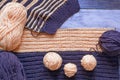 Unfinished knitting, balls of wool and knitting needles on rustic table. Space for text