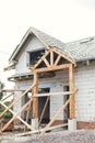 Unfinished modern farmhouse building. Wooden roof framing of mansard with dormer and vapor barrier on aerated concrete block walls Royalty Free Stock Photo