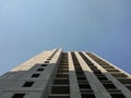 Unfinished multi-storey residential building on a Sunny day. Empty apartment. Bottom-up view. Blue sky