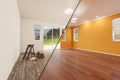 Unfinished Raw and Newly Remodeled Room of House Before and After with Wood Floors, Moulding, Yellow Ochre Paint and Ceiling