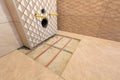 Unfinished reconstruction of bathroom with ceramic tiles installed on walls, heating electrical cables system on cement floor and