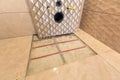 Unfinished reconstruction of bathroom with ceramic tiles installed on walls, heating electrical cables system on cement floor and