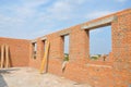 Unfinished Red Brick House Wall under Construction without Roofing. Attic Windows Concrete Lintel Frame Construction. Royalty Free Stock Photo