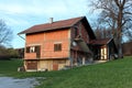 Unfinished red bricks and stone family house without facade surrounded with construction material and green grass next to old tall Royalty Free Stock Photo