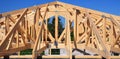 Unfinished roofing wooden frame house construction with roof beams, trusses, timber, braces and eaves of a brick house building