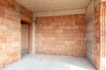 Unfinished room interior of building under construction. Brick red walls. New home Royalty Free Stock Photo