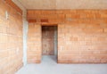 Unfinished room interior of building under construction. Brick red walls. New home Royalty Free Stock Photo