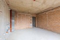 Unfinished room interior of building under construction. Brick red walls. New home Royalty Free Stock Photo