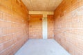 Unfinished room interior of building under construction. Brick red walls. New home Royalty Free Stock Photo