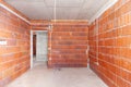 Unfinished room interior of building under construction. Brick red walls. New home Royalty Free Stock Photo