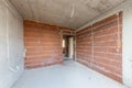 Unfinished room interior of building under construction. Brick red walls. New home Royalty Free Stock Photo