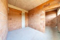 Unfinished room interior of building under construction. Brick red walls. New home