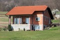 Unfinished small red building blocks family house with new roof tiles surrounded with freshly cut grass and dense trees without Royalty Free Stock Photo