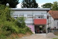 Unfinished small suburban family house surrounded with scaffolding and dense vegetation