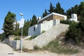 Unfinished strange looking family house with bunker like design and closed window blinds surrounded with traditional stone wall Royalty Free Stock Photo