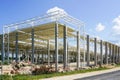 Unfinished warehouse steel frame structure on reinforced concrete supports, corrugated steel roof