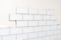 Unfinished white ceramic tiles with tile spacers. Concept of a kitchen renovation. Royalty Free Stock Photo