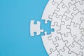 Unfinished white jigsaw puzzle pieces on blue background, The last piece of jigsaw puzzle, Copy space Royalty Free Stock Photo