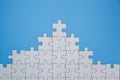 Unfinished white jigsaw puzzle pieces on blue background, The last piece of jigsaw puzzle, Copy space Royalty Free Stock Photo