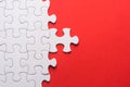 Unfinished white jigsaw puzzle pieces on red background Royalty Free Stock Photo