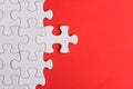 Unfinished white jigsaw puzzle pieces on red background Royalty Free Stock Photo