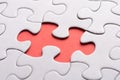 Unfinished white jigsaw puzzle pieces on red background Royalty Free Stock Photo