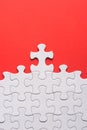 Unfinished white jigsaw puzzle pieces on red background Royalty Free Stock Photo