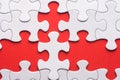 Unfinished white jigsaw puzzle pieces on red background Royalty Free Stock Photo