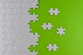 Unfinished white puzzle pieces on a green background Royalty Free Stock Photo