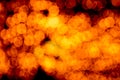 Unfocused abstract orange bokeh on black background. defocused and blurred many round light