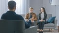 Unfocused Couple on Counseling Session with Psychotherapist. Focus on Back of Therapist Taking Notes Royalty Free Stock Photo