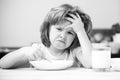 Unfocused little boy having soup for lunch. Unhappy Caucasian child sit at table at home kitchen have no appetite. Upset Royalty Free Stock Photo