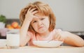 Unfocused little boy having soup for lunch. Unhappy Caucasian child sit at table at home kitchen have no appetite. Upset Royalty Free Stock Photo