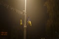 Unfocused night shot of Christmas garland lights bokeh in the Ukrainian city. Ukrainian yellow and blue flags. Happy New Year Royalty Free Stock Photo