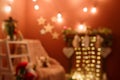 Unfocused shot. Blurry Christmas background with arm-chair and fireplace decorated with hanging socks, fir branches Royalty Free Stock Photo